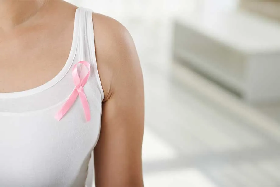 Beyaz atletin üzerine iliştirilmiş pembe kanser farkındalık kurdelesi